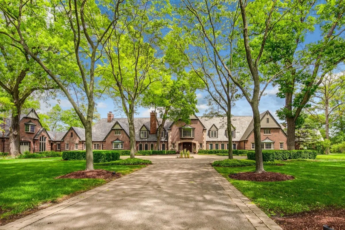 Luxury estate exterior with tree-lined drive